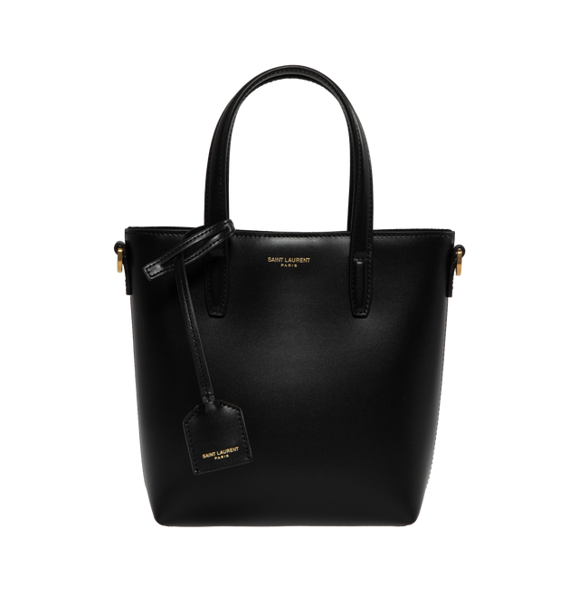 Image 1 of 3 - BLACK - Saint Laurent Mini tote bag embossed with "Saint Laurent Paris" and decorated with a removeable leather-encased Cassandre charm. Features magnetic snap closure, flat leather top handles and an adjustable and detachable strap for multiple carry options.  Lambskin leather with bronze-tone hardware. Measures 7.1" X 6.7" X 3.1" with handle drop 3.3" and strap drop 19.7". Made in Italy.  