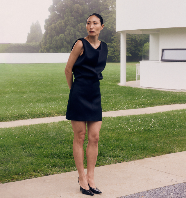 Image 4 of 5 - BLACK - KHAITE Toma Dress featuring a sculptural minidress that doubles as a tunic. Sharpened by clean shoulders and animated by bonded Italian crepe. Undulating bodice designed to blossom and bloom from slim-fitting skirt. Concealed zipper closure at back. 83% acetate, 17% viscose. 