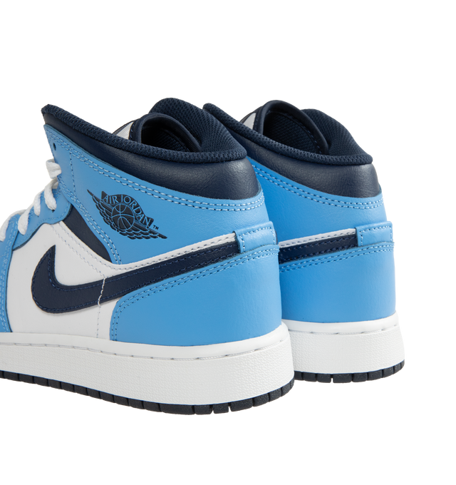 Image 3 of 5 - BLUE - Men's Air Jordan 1 Mid Sneakers feature a leather, synthetic leather, and textile upper with the iconic mid-top silhouette for a timeless heritage look. These lifestyle sneakers combine lightweight Nike Air cushioning, a foam midsole, and a durable rubber outsole with a pivot-circle traction pattern for lasting comfort, support, and reliable grip. Main Material: Leather, Synthetic Leather, and Textile. Midsole: Foam with Nike Air Cushioning. Sole: Rubber. 