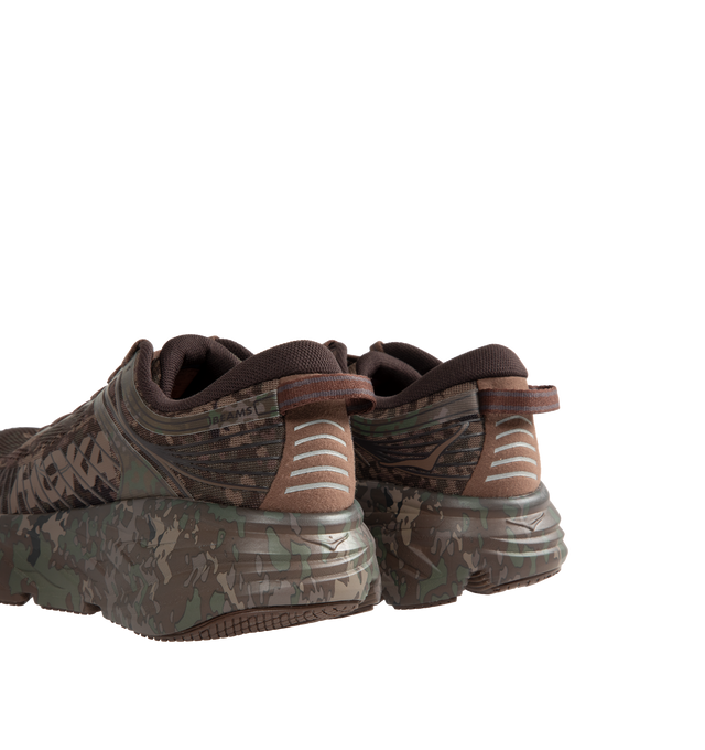 Image 3 of 5 - BROWN - Hoka Unisex Bondi 7 Beams Sneakers reinterpret the ultra-cushioned silhouette with a custom camouflage upper inspired by Japanese Zen gardens. The vegan open-mesh construction features a memory foam collar, TPU overlays, 3D-printed logos, a reflective secondary lace, and a lace keeper. Upper: Vegan Mesh and TPU. *Unisex style in men's sizing. 
