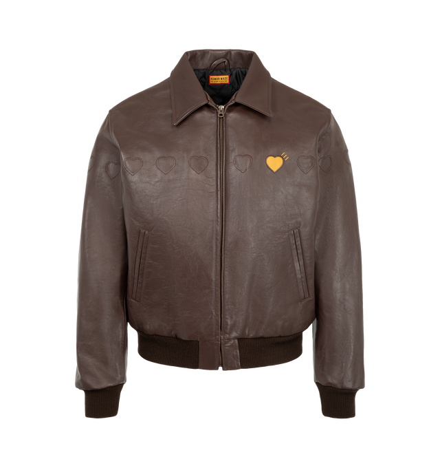 Image 1 of 3 - BROWN - Human Made Men's Leather Jacket is crafted from cow leather and features a classic silhouette with a quilted polyester taffeta lining for added comfort and warmth. Designed with heart-shaped cutout detailing across the front, this statement outerwear style is finished with signature yellow heart logos at the left chest and back, along with rib-knit cuffs and hem for a secure fit. Main Material: Cow Leather. Lining: Quilted Polyester Taffeta.  