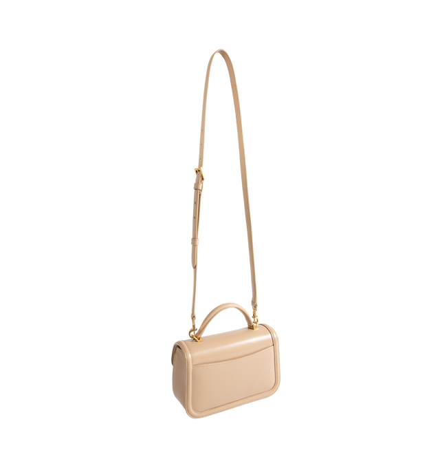 Image 2 of 3 - NEUTRAL - Saint Laurent Women's Mini Top-Handle Bag is crafted from box calfskin leather and features the iconic Cassandre sliding clasp closure, a structured top handle, a detachable and adjustable shoulder strap, bronze-tone hardware, a suede-lined interior, one card slot, and a rear flat pocket. This designer leather top-handle bag combines timeless elegance with versatile styling for day-to-evening wear. Main Material: Calfskin Leather. Lining: Suede. Hardware: Brass. Dimensions: 19.5 x 1 
