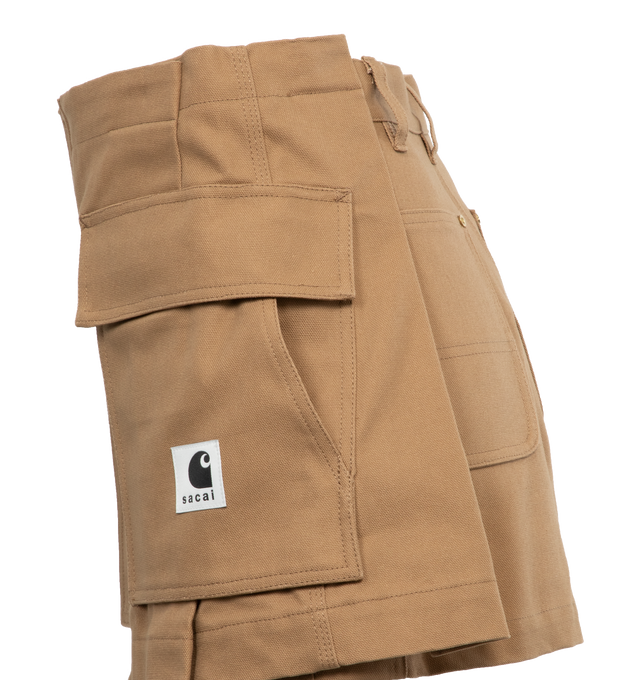Image 3 of 4 - BROWN - SACAI X CARHARTT WIP Canvas shorts with zip and double button closure, pockets and front logo patch, hammer loop detail at the back pocket,  belt loops, gold tone hardware. Features skirt overlay in front with cargo pockets, zip and button closure. Women's Japanese sizing. JP size 1 = US X-small. JP size 2 = US small. JP size 3 = US medium. JP size 4 = US large.   