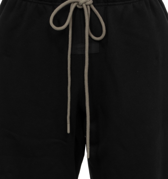 Image 4 of 4 - BLACK - Fear of God  Essentials lounge sweatpant made in core fleece and designed in a wide-leg fit for pronounced drape. Featuring rubberized label at the center front, encased elastic waistband with elongated drawstrings with rubberized tips and side seam pockets. 80% cotton, 20% polyester heavyweight fleece. 