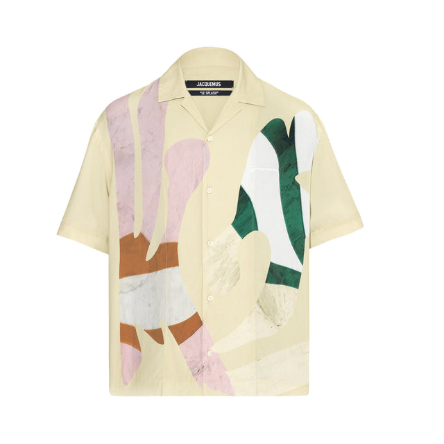 Image 1 of 1 - YELLOW - JACQUEMUS La chemise Jean Shirt featuring viscose satin, graphic pattern printed throughout, camp collar, button closure, logo embroidered at chest, locker loop at back yoke and mother-of-pearl hardware. 100% viscose. Made in Portugal. 