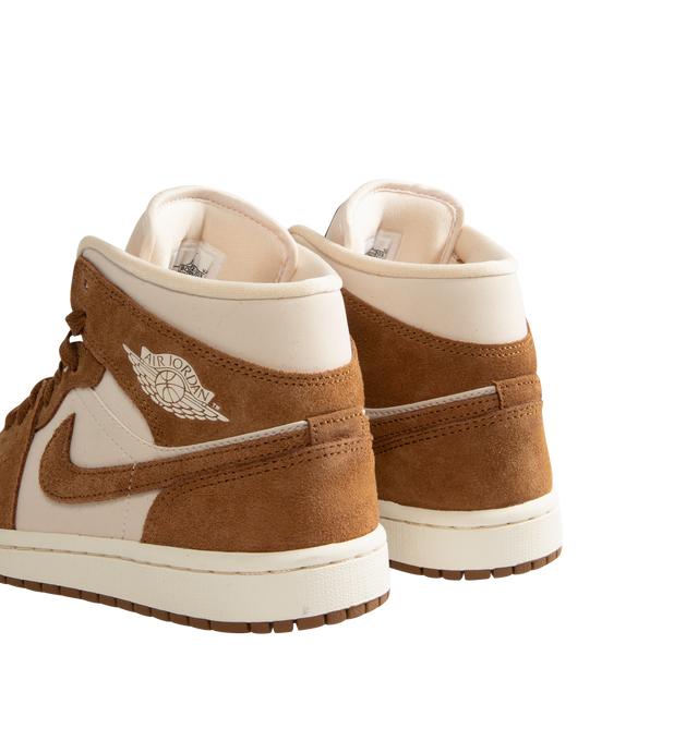 Image 3 of 5 - BROWN - Women's Air Jordan 1 Mid Sneakers feature a genuine and synthetic leather upper with a classic mid-top silhouette for durable comfort and timeless style. Inspired by the iconic original, these lifestyle sneakers combine lightweight Air-Sole cushioning, a padded collar, and a durable rubber outsole for everyday support and reliable traction. Main Material: Genuine Leather and Synthetic Leather. Midsole: Foam with Air-Sole Unit. Sole: Rubber. 