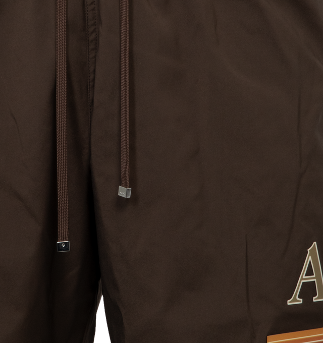 Image 4 of 4 - BROWN - AMIRI Swimshort featuring a gradient bar logo at the left thigh, crafted with side seam pockets, back flap pocket, elastic waist and drawcord. Made in Italy.  90% POLYESTER 10% SPANDEX. 