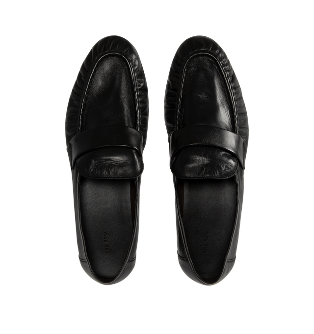 Image 4 of 4 - BLACK - THE ROW Soft Loafers featuring polished eel leather loafers, topstitching and gathering at moc toe, strap at vamp, logo stamp at footbed, suede lining, stacked leather block heel and hand-painted leather sole with rubber injections. Heel: H1". Leather. Made in Italy. 