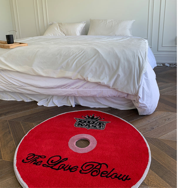 Image 2 of 4 - RED - Curves at Home The Love Below CD Rug. The rug collection highlights a collection of iconic albums. Handmade and hard wearing, it can be displayed as a floor rug or a wall hanging. Hand tufted acrylic with dye-cut center, cotton non-slip backing and binded edges . W 35" x L 35" x D 0.78". *These items are handmade, each rug may come with a slight variation.* 