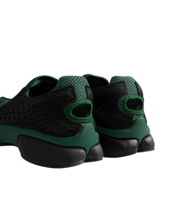 Image 2 of 5 - BLACK - Nike Women's Air Rift 2 Kenya Sneakers reinterpret the iconic split-toe silhouette with a colorway inspired by Kenya and its renowned running heritage. Designed in black, Fire Red, and Team Dark Green, these sneakers reference the colors of the Kenyan flag while honoring the barefoot running traditions that originally influenced the Air Rift design. The updated Air Rift 2 construction retains the distinctive split-toe profile and natural-motion-inspired shape while refining the origin 
