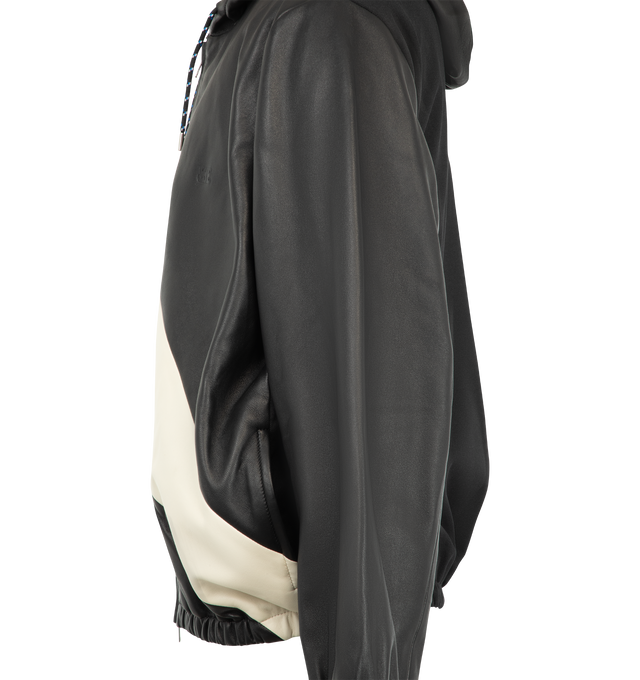 Image 3 of 3 - BLACK - Wales Bonner Men's Vista Leather Anorak is crafted from soft plong leather and technical twill and features a relaxed silhouette in a black and ivory colorway. Inspired by ceremonial dress, the design is detailed with a contrasting sash-style panel across the front, a drawstring hood, and a two-way zip closure. Finished with zip seam pockets, elasticized cuffs and hem, dropped shoulders, and an embossed logo at the chest. 68% Polyester, 18% Polyacrylic, 12% Rayon, 2% Polyurethane. Con 