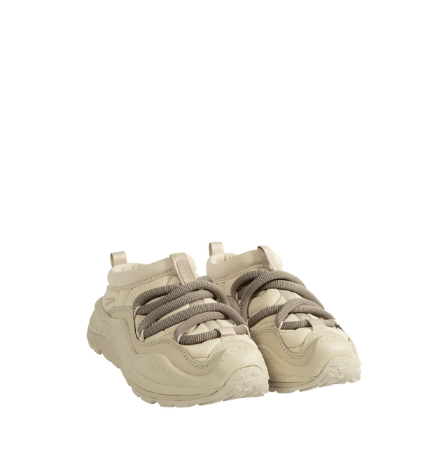 Image 2 of 5 - NEUTRAL - Hoka Unisex Ora Primo Sneaker featuring soft knit collar, insulated puff upper, slip-on style, zig-zag stitch detail, round elastic lace system and protective toe bumper. Nylon, textile. Rubber sole. *Unisex style in men's sizing.  