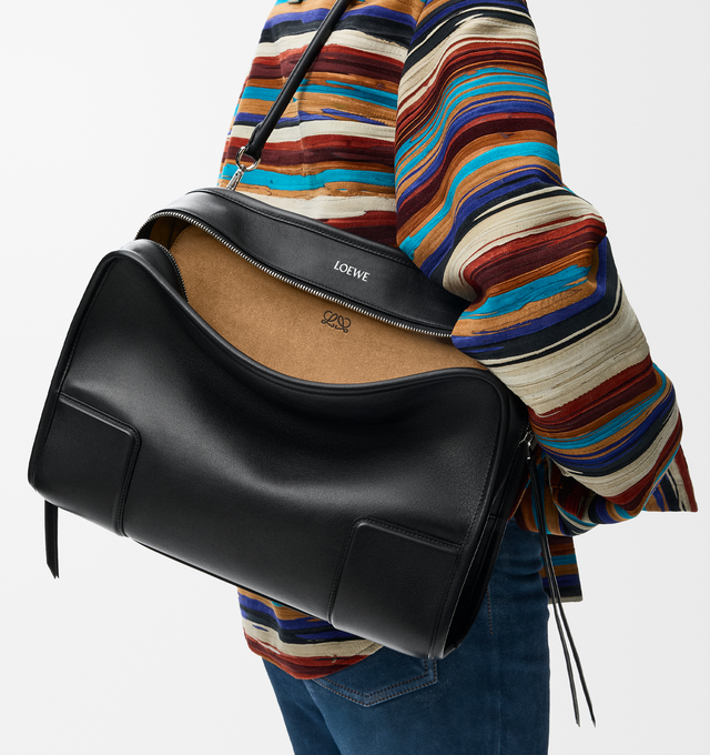 Image 14 of 16 - BLACK - Loewe Amazona 180 large bag takes on a relaxed silhouette anchored by a single toron top handle. It is designed to be carried open, while a concealed closure secures the main compartment. Removable shoulder and crossbody straps make it highly versatile. This large version is crafted in soft calfskin. Three carry options: short handle, removable shoulder strap and crossbody. Features zip closure with two leather zip pullers, two compartments, main compartment closed with magnetic clo 