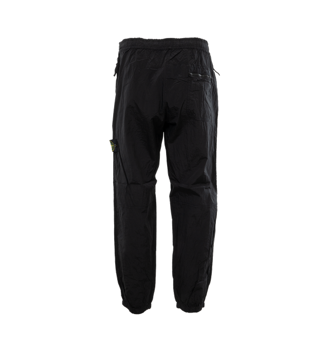 BLACK - STONE ISLAND Regular Fit Sweatpants featuring valet stand hand pockets with zipper closure inner tape edging, one patch pocket on back with horizontal zipper closure topped with nylon tape, Stone Island badge on the left leg, elasticized leg bottom and elasticized waistband with inner drawstring. 100% polyamide/nylon. 