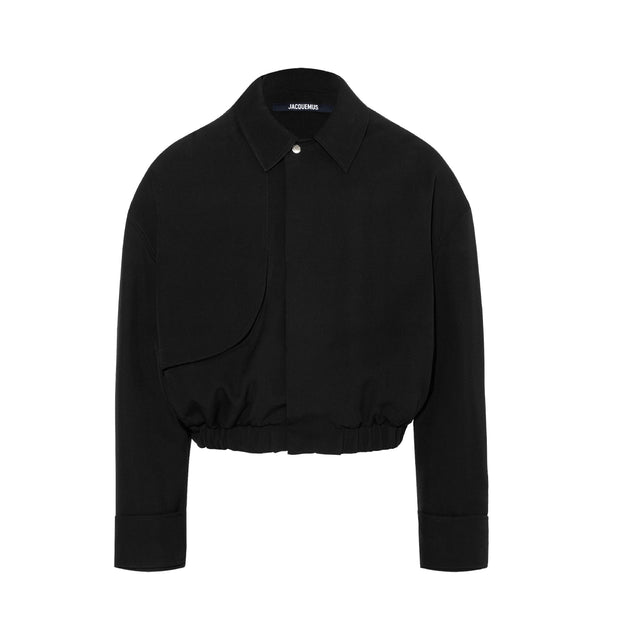 Image 1 of 1 - BLACK - JACQUEMUS Trench bomber featuring classic fit, cotton linen canvas, pointed collar, shoulder flap, hidden welt pocket, hidden snap button placket with one visible button, silver metal hardware and elasticated waistband. 82% cotton, 18% linen. Lining: 100% viscose. Made in Bulgaria.