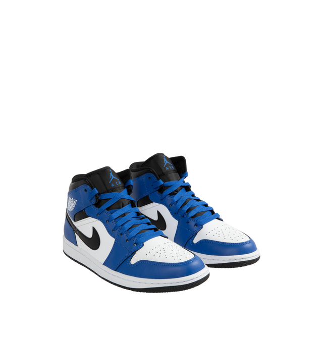 Image 2 of 5 - BLUE - AIR JORDAN 1 MID basketball shoe in white, royal blue and black leather upper featuring an angled profile, toe box perforations, mesh tongues and lining, encapsulated Air cushioning underfoot, and distinctive Jordan detailing. Air-Sole cushioning provides lightweight, responsive comfort.  Leather and textile upper/synthetic lining/rubber sole. 