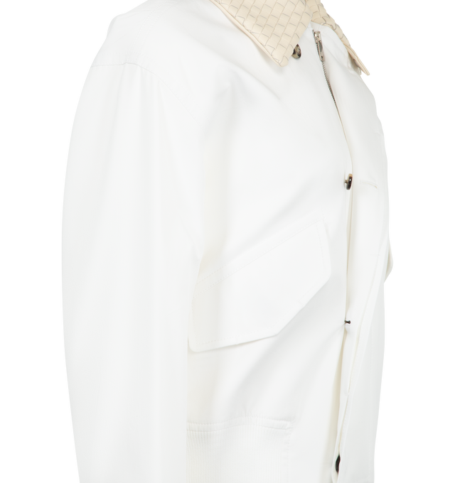 Image 3 of 3 - WHITE - Bottega Veneta Women's Cotton Blouson is crafted from lightweight water-repellent cotton and features a relaxed silhouette with an Intrecciato leather collar, a detachable Intrecciato leather throat latch, and a zip-and-button front closure. Fully lined for added comfort, this designer jacket combines signature Bottega Veneta craftsmanship with functional outerwear details, creating a refined everyday layering piece. Main Material: 100% Cotton. Made in Italy. 
