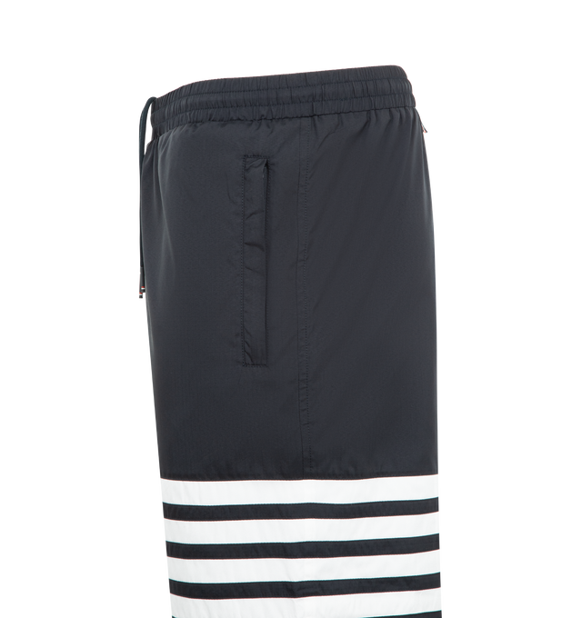 Image 3 of 3 - NAVY - THOM BROWNE Shiny Ripstop 4 Bar Track Pant featuring elasticated waistband with internal drawstring, zip fly, hand pockets and back pocket with hidden zips, elasticated cuffs, mesh lining, 4-bar detailing and signature striped grosgrain loop tab. 81% polyamide, 19% polyester. Made in Italy. 