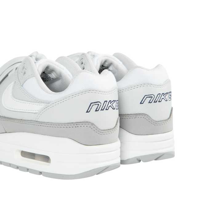 WHITE - Nike's Air Max 1 '87 sneakers crafted from white and grey calf leather and fabric combination with signature Swoosh logo on the sides, round toe, front lace-up fastening, logo-print tongue, branded heel counter, branded insole and signature Air Max 100% rubber sole. 