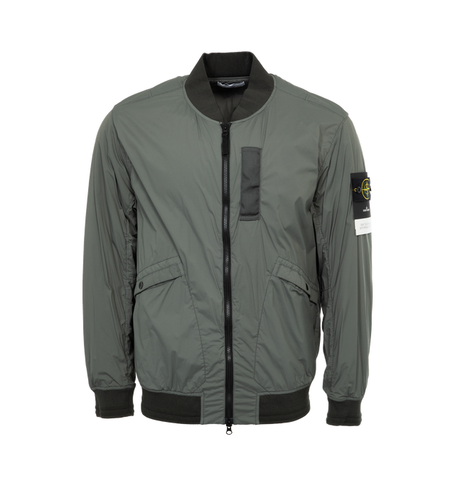 Image 1 of 3 - GREEN - STONE ISLAND Bomber Jacket featuring rib knit stand collar, hem, and cuffs, two-way zip closure, welt pockets, detachable logo patch at sleeve and full taffeta lining. 89% polyamide, 11% elastane. Made in Indonesia. 