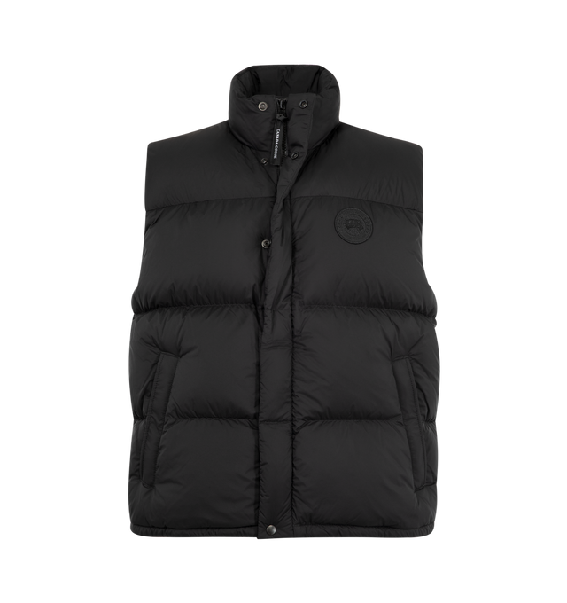 Image 1 of 2 - BLACK - Canada Goose Men's Sterling Puffer Vest is crafted from plain-weave polyamide and features a regular-fit silhouette with wide quilted baffles for a contemporary look. Designed to provide wind-resistant and water-repellent protection, this lightweight vest is finished with a tall collar for added coverage, a concealed snap placket over a front zip closure, and an adjustable drawcord hem for a customizable fit. Functional details include two exterior zippered welt pockets, one interior  