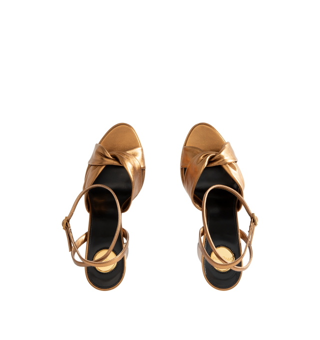Image 4 of 4 - GOLD - Saint Laurent Womens Platform Sandals are crafted from calfskin leather. Feature a twisted crisscross toe, adjustable ankle strap with CASSANDRE charm, block heel, leather sole, and 13.9 cm heel height, 8.5 cm arch height and 5.4 cm platform height.  Main Material: Calfskin Leather; Hardware: Brass; Sole: Leather. Made in Italy. 