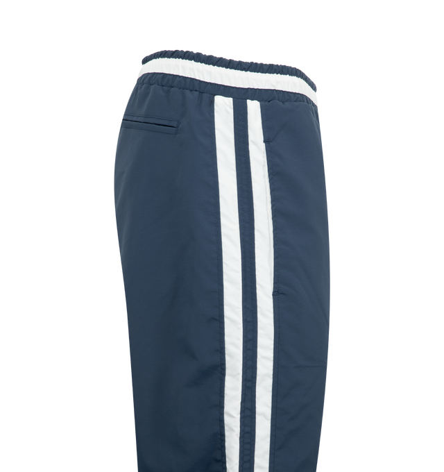 Image 3 of 3 - NAVY - Rhude Champions Track Pants featuring drawstring at elasticized waistband, three-pocket styling, logo printed at front, stripes at outseams and full twill lining. 100% polyester. Made in United States. 