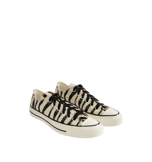 Image 2 of 5 - MULTI - Converse retro animal print Chuck 70 low top lace-up sneaker glows in the dark. Featuring timeless canvas upper, OrthoLite cushioning providing optimal comfort, black flat lace ties, Iconic Chuck Taylor patch. Unisex style in men's sizes. This style runs large- order 1/2 size down. 