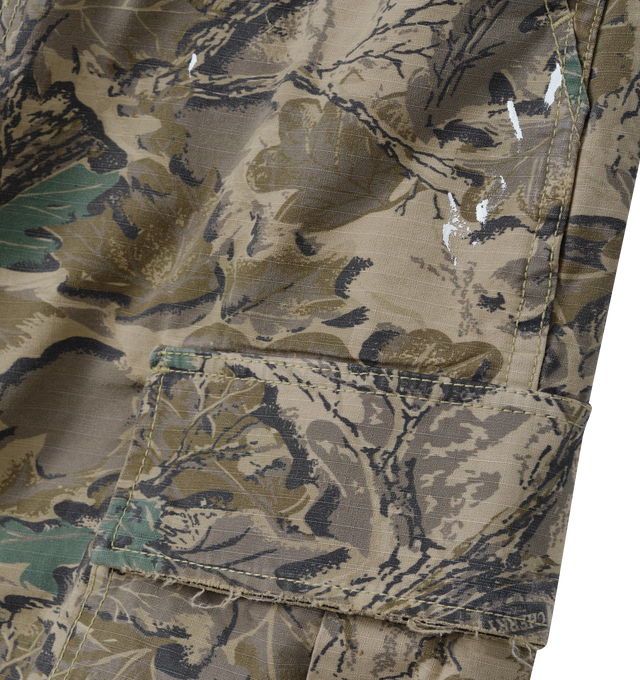 Image 3 of 7 - GREEN - Cherry LA Wide Leg Cargo Pants are crafted from custom camouflage cotton ripstop and feature a wide-leg silhouette with utility-inspired cargo pocket detailing. Designed with hidden snap closures at the pockets, paint splatter accents, and distressed finishes throughout, this statement style combines military influences with Cherry LA's signature lived-in aesthetic. Main Material: Custom Camouflage Cotton Ripstop. Fit: Wide Leg. Pockets: Cargo Pockets with Hidden Snap Closures. Detail 
