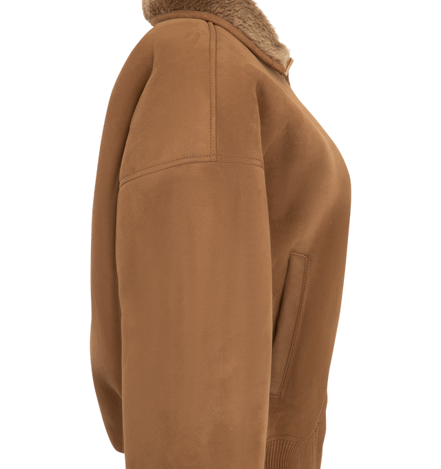 Image 3 of 3 - BROWN - Acne Studios Women's Shearling Bomber Jacket is crafted from lamb shearling and features a relaxed-fit silhouette with a below-waist length, a funnel neckline, and dropped shoulders. Designed with a two-way zip closure, welt pockets, and ribbed trims at the waist and cuffs that create a gathered effect, this elevated outerwear style is finished with a metal logo plaque at the back neckline. Main Material: 100% Lamb Shearling. Contrast: 100% Goat Leather.  