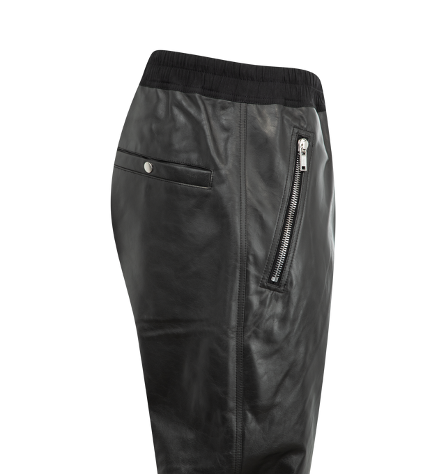 Image 3 of 3 - BLACK - Rick Owens Tecuatl Track Trousers featuring coated plain-woven organic cotton, drawstring at elasticized waistband, four-pocket styling, button fly, zip vent at elasticized cuffs, cargo pocket at outseams and horn hardware. 100% organic cotton. Made in Italy. 