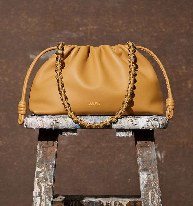 Image 4 of 5 - BROWN - Loewe Flamenco Purse crafted in mellow nappa lambskin in a ruched design featuring knots at the sides, magnetic closure and detachable donut chain. Versatile and functional, it can be carried as a clutch, worn over the shoulder using the donut chain or crossbody with the accompanying leather strap.  Nappa leather with suede lining. Height 7.9" X Width 11.8" X Depth 4.1". Adjustable Strap length (inches) 37" to 47". Made in Spain. 