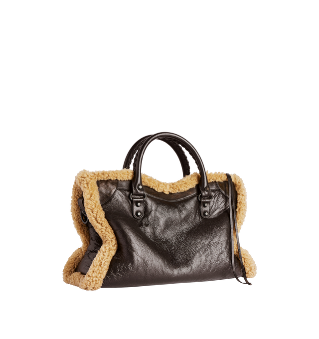 Image 2 of 4 - BROWN - BALENCIAGA Le City Bag Medium in brown calfskin and beige shearling, brass hardware featuring two leather hand-braided handles, adjustable and removable shoulder strap, ribbon with Balenciaga logo on the front, zipped closure with knotted leather puller, front zipped pocket with knotted leather puller, 1 inner zipped pocket and cotton canvas lining. 15.1" x 9.4" x 5.3". Calfskin, shearling, polyester. Made in Italy. 