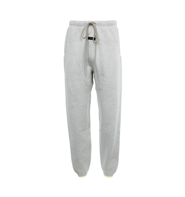 Image 1 of 4 - GREY - FEAR OF GOD ESSENTIALS Drawstring Sweatpants featuring drawstring at elasticized waistband, two-pocket styling, rubberized logo patch at front and elasticized cuffs. 80% cotton, 20% polyester. Made in Viet Nam. 