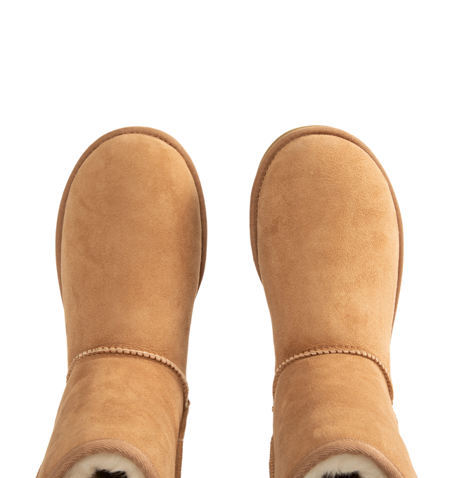 Image 4 of 4 - BROWN - UGG Men's Classic Short Boots are crafted from premium suede and feature the brand's iconic mid-calf silhouette with a soft sheepskin lining and cushioned footbed for signature warmth and comfort. These designer boots combine timeless style with lightweight cushioning and a durable outsole, making them an everyday cold-weather essential. Main Material: Suede. Lining: Sheepskin. Sole: Durable Rubber. 