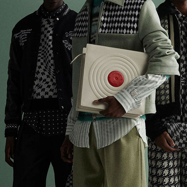 Men wearing Amiri apparel carrying an Amiri record bag, available online.