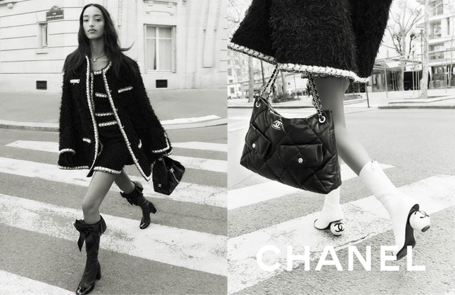 Person wearing a Chanel outfit with a handbag on a city street.
