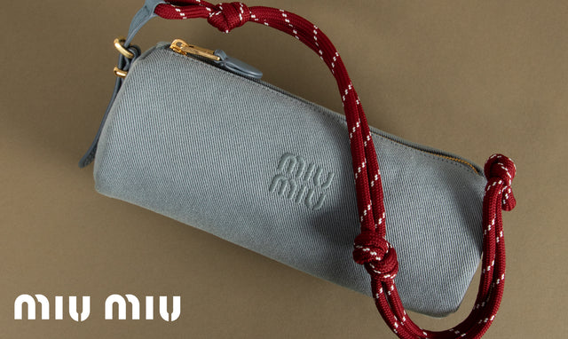 Gray handbag with a red strap on a beige background, featuring the Miu Miu logo.