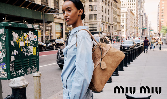 Model in NYC wearing Miu Miu denim jumpsuit carrying Miu Miu large tan suede bag