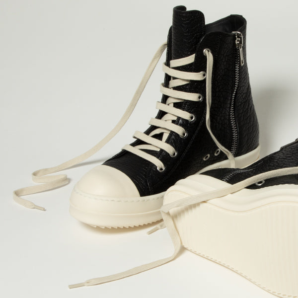 Rick Owens black high-top sneakers with thick off-white soles, off-white laces, and a side zipper