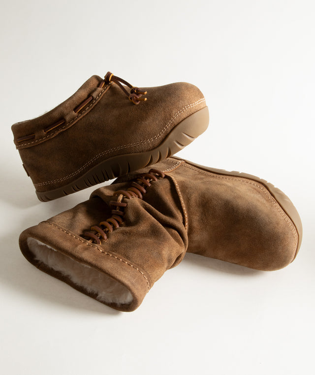 A pair of brown suede UGG boots with laces and a soft shearling lining, displayed on a clean white background. 