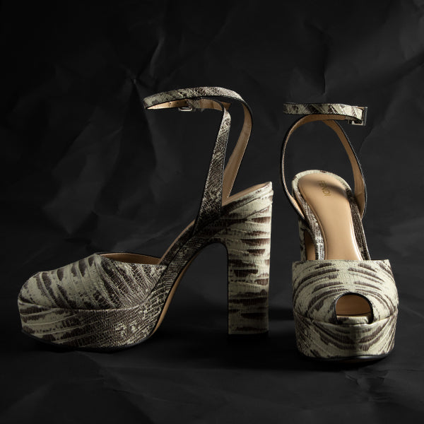 Fendi women's platform high-heeled sandals with an abstract black, gray, and beige textured pattern, shown against a dark crumpled black background.