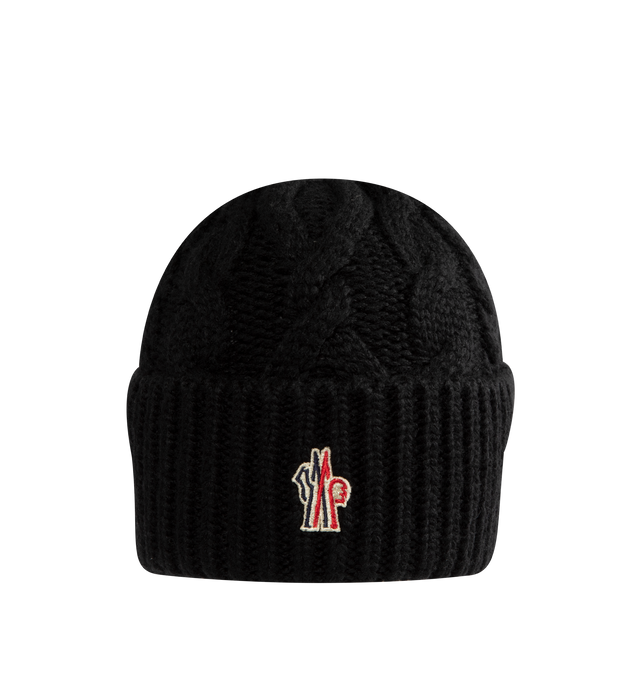 Image 1 of 2 - BLACK - Moncler Grenoble Women's Wool Blend Cable Knit Hat is crafted from a wool blend and features a classic cable-knit construction inspired by alpine textures. Designed as a timeless cold-weather accessory, this beanie is finished with a folded rib-knit cuff and a Moncler Grenoble logo patch at the front. Main Material: Wool Blend.  