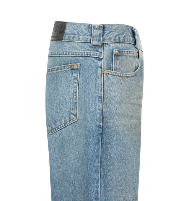 Image 3 of 3 - BLUE - Willy Chavarria Men's Flared Denim Jean is crafted from washed cotton denim and features a relaxed fit through the hip and thigh with a wide, slightly flared leg that creates an elongated silhouette. Designed with an intentional dirty finish, this designer jean is detailed with a branded gold-tone button closure, key loop, signature W belt loop at the back, and a branded leather patch. Main Material: 100% Cotton. Made in USA. 
