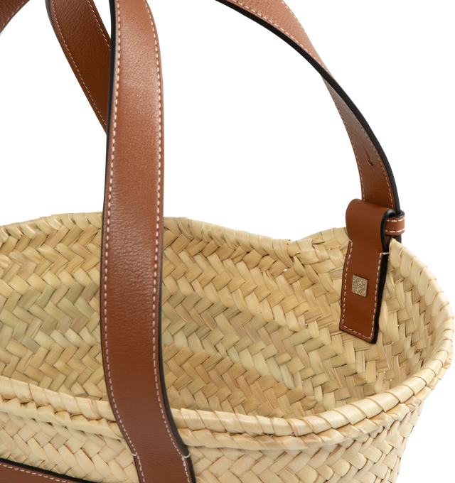 Image 3 of 3 - NEUTRAL - LOEWE small traditional basket bag elevated with a classic handwoven body and calfskin top handles. This small version is made in Spain using raffia leaves that have been cultivated, harvested, sun-dried and handwoven by artisans in Morocco. Featuring contrast straps and panel, shoulder or top handle carry, adjustable top handles, unlined, embossed LOEWE Anagram calfskin patch. 