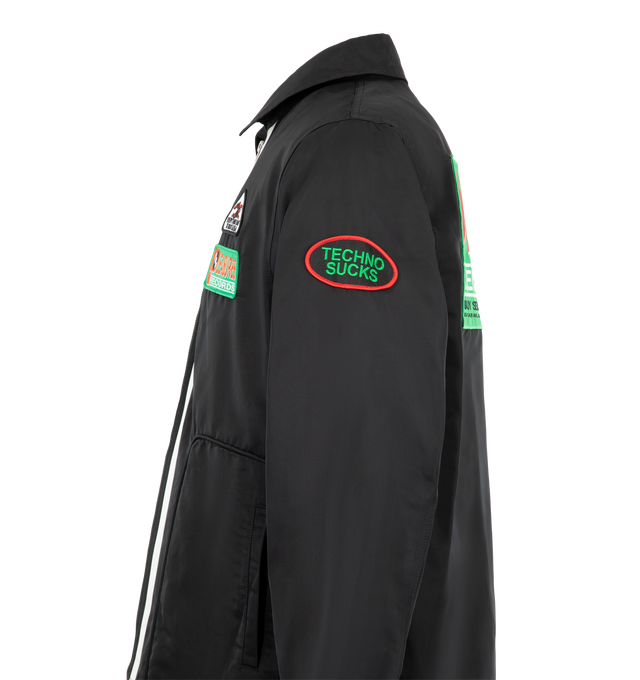 Image 3 of 4 - BLACK - Pleasures Men's Records Jacket is designed with a structured silhouette and features a point collar, full two-way zip closure, and multiple embroidered and appliqu graphic patches throughout. A contrasting striped panel in green and white runs alongside the front zipper, while welt pockets and adjustable button tabs at the hem complete the design. Main material: Polyester. 