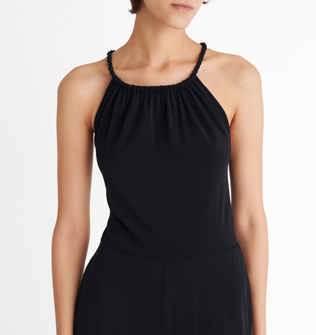 Image 5 of 5 - BLACK - ERES Donna Jumpsuit featuring sliding and twisted link to tie around the neck, adjustable straps crossed in the back, high neckline with shirring, open back and two side pockets. 94% Polyamid, 6% Spandex. Made in France.  