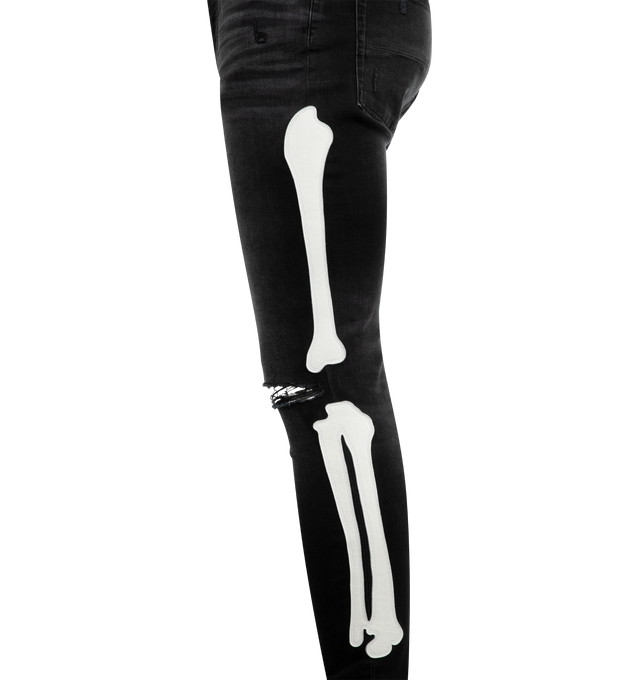 Image 3 of 4 - BLACK - AMIRI Bones Applique Distressed Jeans featuring white leather bones throughout side seams, distressed details throughout, tapered fit and ripped knees. 92% cotton, 6% elastomultiester, 2% elastane. 
