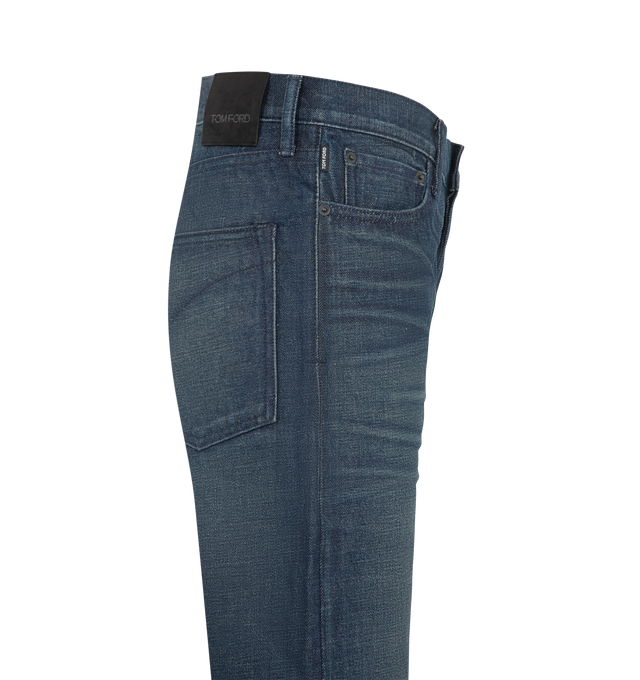 Image 3 of 3 - BLUE - TOm Ford Women's Stonewashed Denim Low Waist Boyfriend Denim Pants are crafted from premium Japanese denim and feature a relaxed boyfriend silhouette with a low-rise waist and classic five-pocket construction. Finished with a stonewashed indigo treatment, this timeless style blends American denim heritage with TOM FORD's refined aesthetic through signature tack button closures, rivets, and an embossed Alcantara logo patch at the back. Main Material: 100% Cotton. Made in the USA. 