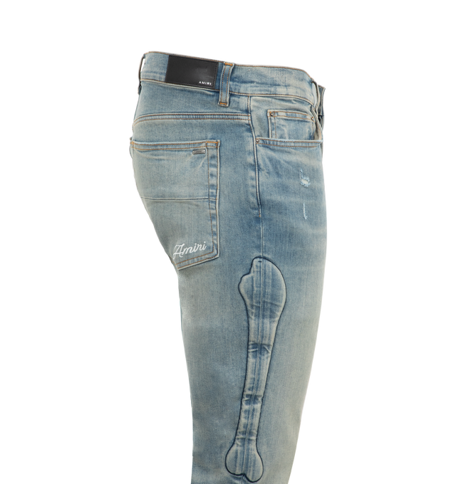 Image 3 of 3 - BLUE - Amiri 3D Bones Skinny Jeans are a 5-pocket style with button fastenings, all-over distressing, and dimensional bone motifs at the sides 92% cotton, 6% elastomultiester, 2% elastane.  